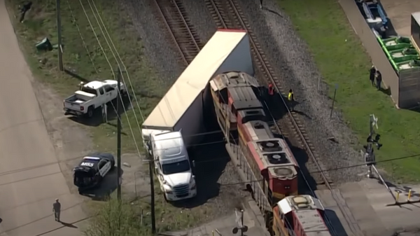 Un tren impacta contra un camión cargado de autos de lujo - Sputnik Mundo