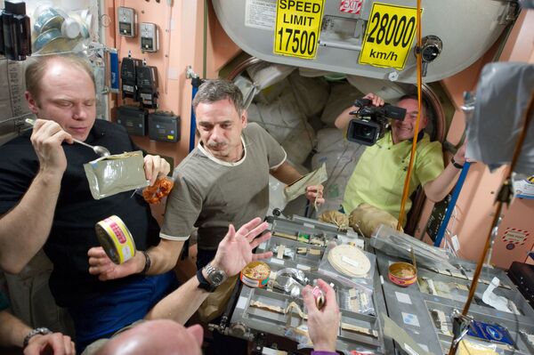 Miembros de la Expedición 23 (Oleg Kotov, Mijaíl Kornienko y Alexandr Skvortsov) durante el almuerzo.  - Sputnik Mundo