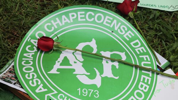 Una flor sobre el escudo del club Chapecoense luego de la tragedia aérea de 2016 - Sputnik Mundo