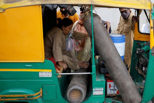 Una mujer con una máscara de oxígeno espera su turno para ser hospitalizada en la ciudad de Ahmedabad.  - Sputnik Mundo