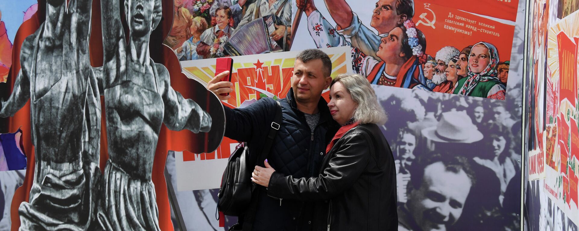 La gente se toma fotos frente a los carteles soviéticos para la fiesta del 1 de mayo - Sputnik Mundo, 1920, 01.05.2021