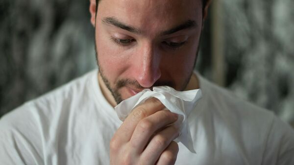 Un hombre se limpia la nariz con un pañuelo de papel - Sputnik Mundo