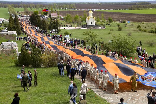 Activistas llevan una cinta de San Jorge de 300 metros, que se ha convertido en un símbolo de la insurgencia prorrusa en el este de Ucrania, a un monumento de la Segunda Guerra Mundial en el montículo de Saur-Mogila, a unos 60 km al este de Donetsk.  - Sputnik Mundo