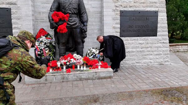 El sacerdote de las Fuerzas Armadas de Estonia deposita una ofrenda floral frente al Monumento a los caídos durante la Segunda Guerra Mundial (también conocido como el Soldado de Bronce o el Monumento a los Libertadores de Tallin) en un cementerio militar de Tallin.   - Sputnik Mundo