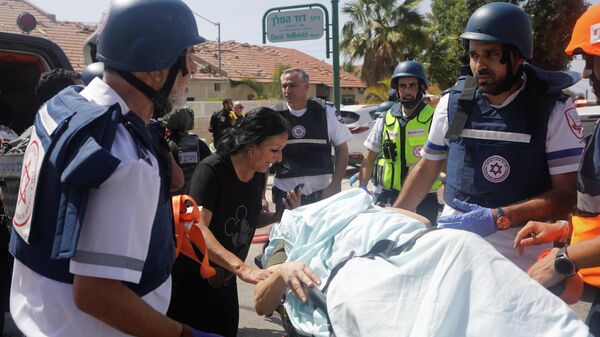 Los médicos evacuan a una persona herida después de que un cohete lanzado desde la Franja de Gaza golpeara una casa en Ashkelon, Israel - Sputnik Mundo
