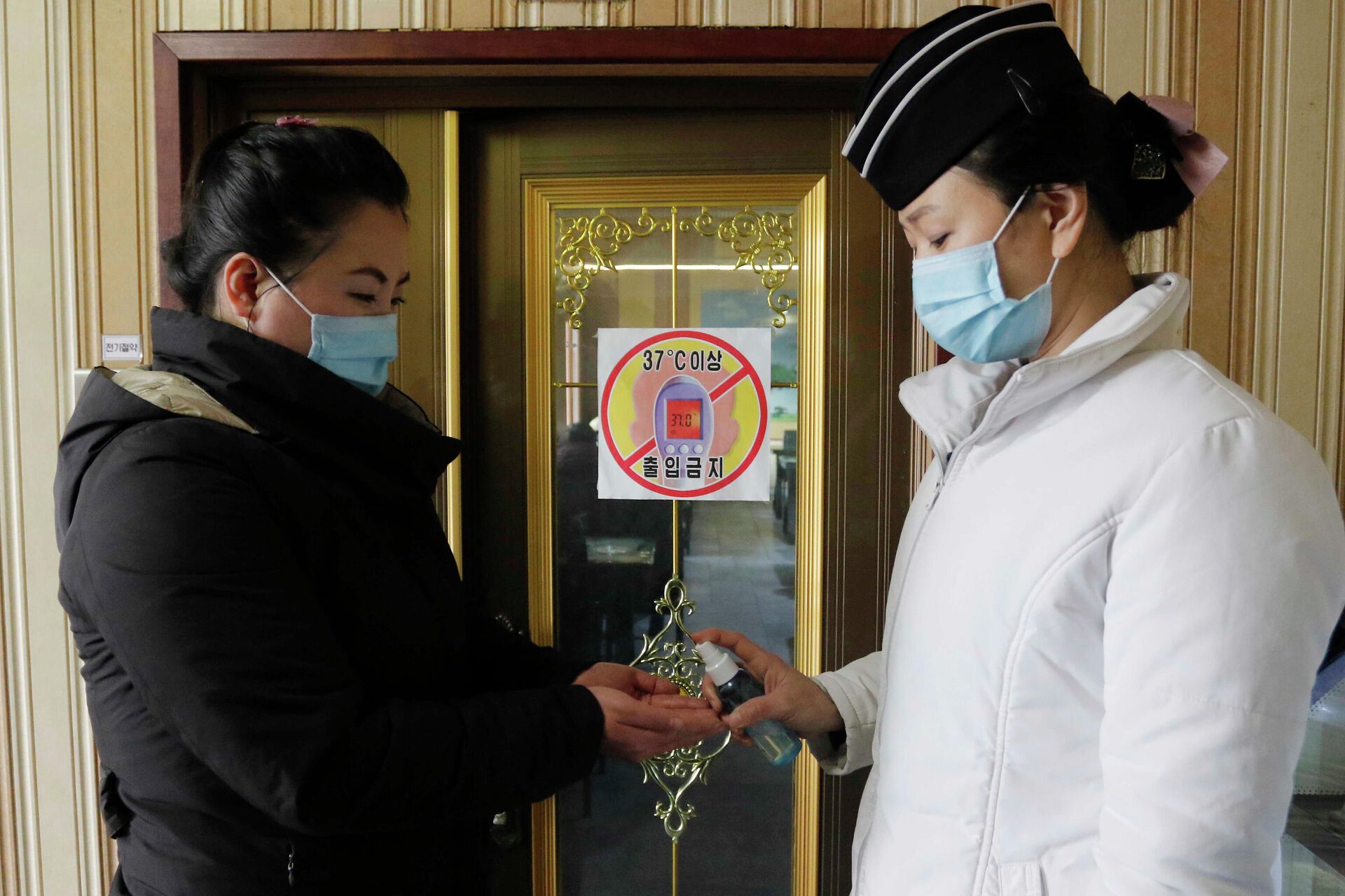 Empleada de un restaurante en Pyongyang desinfecta las manos de una clienta - Sputnik Mundo, 1920, 19.05.2021