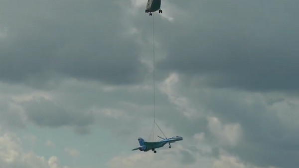 La increíble operación para transportar un caza colgado de un helicóptero   - Sputnik Mundo