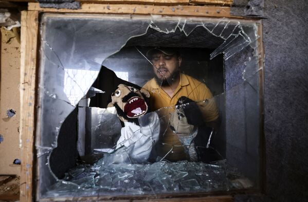 Mohammed Saed, un comediante palestino, muestra títeres que rescató de su estudio, dañado durante un reciente bombardeo israelí en Gaza (Palestina). - Sputnik Mundo