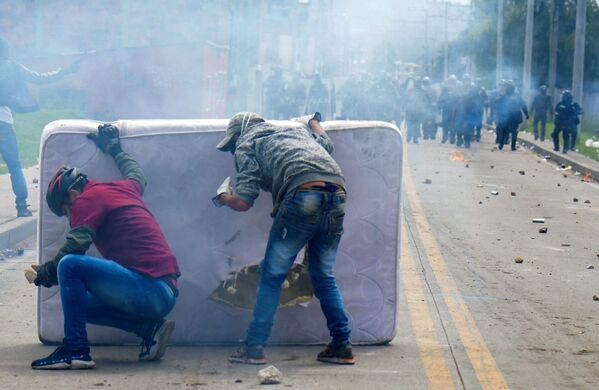 Unos manifestantes se protegen detrás de un colchón durante los enfrentamientos con la policía antidisturbios que estallaron durante una protesta contra el Gobierno del presidente colombiano Iván Duque, en Facatativá (Colombia). - Sputnik Mundo