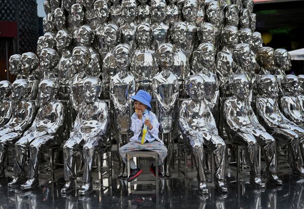 Un niño posa entre unas esculturas en exhibición en un centro comercial en Pekín (China). - Sputnik Mundo