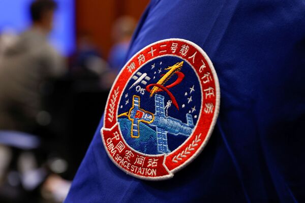 La tripulación actual permanecerá en órbita hasta septiembre, tras lo cual será sustituida por otros tres taikonautas. En la foto, el emblema de la misión espacial tripulada Shenzhou 12. - Sputnik Mundo
