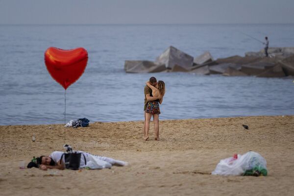 Unos enamorados a primera hora de la mañana en la playa de Barcelona, España. - Sputnik Mundo
