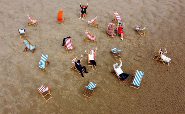 La gente se hace fotos en las tumbonas de la playa británica de Blackpool. Se vuelven a alquilar tras un paréntesis de 10 años. - Sputnik Mundo