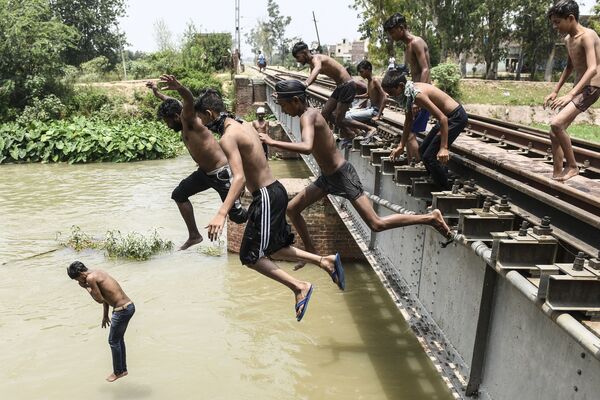 Unos adolescentes saltan a un canal en Amritsar, en la India. - Sputnik Mundo