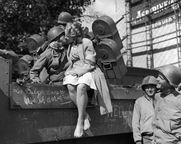 Una mujer de la ciudad belga Lieja, recién liberada de los nazis, besa a un soldado estadounidense, 1944. - Sputnik Mundo