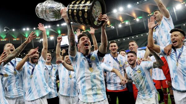 El futbolista argentino Lionel Messi y sus compañeros celebran con el trofeo en las manos su victoria sobre Brasil en la final de la Copa América 2021 celebrada en el Estadio de Maracaná, Río de Janeiro (Brasil), el 10 de julio de 2021  - Sputnik Mundo