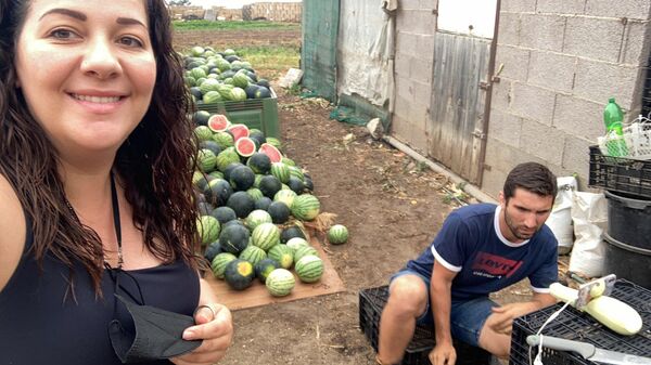 El agricultor Sergio Rodríguez junto a su novia y las sandías - Sputnik Mundo