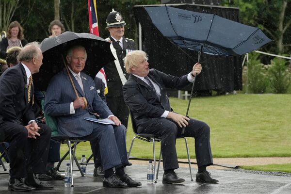 El príncipe Carlos y el primer ministro del Reino Unido, Boris Johnson, se refugian de la lluvia durante la inauguración de un monumento a la Policía del país. El príncipe Carlos y el primer ministro del Reino Unido, Boris Johnson, se refugian de la lluvia durante la inauguración de un monumento a la Policía del país. - Sputnik Mundo