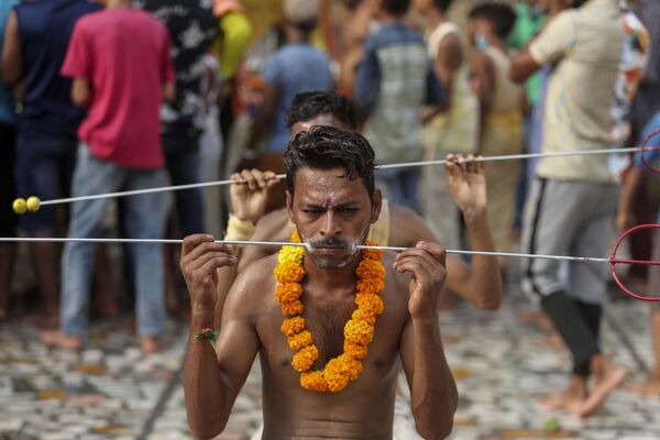 Unos devotos, con las mejillas perforadas como parte de un ritual, se preparan para comenzar una peregrinación anual al templo de la diosa hindú Shitalá en Jammu (la India). - Sputnik Mundo
