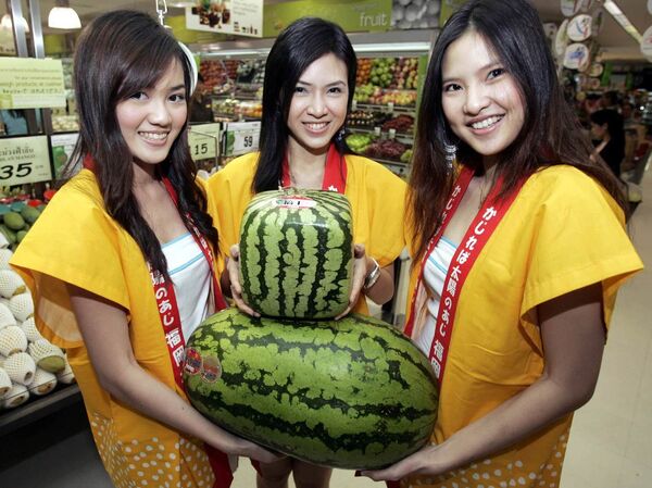 Unas modelos posan con unas sandías insólitas importadas de Japón, durante el Festival de Frutas Japonesas celebrado en Bangkok. - Sputnik Mundo
