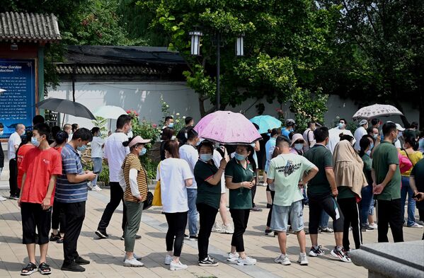 Una de las calles afectadas en Wuhan fue declarada zona de riesgo medio, con la imposición de restricciones correspondientes. En la foto: varias personas hacen cola para realizarse la prueba de coronavirus en un parque de Pekín. - Sputnik Mundo