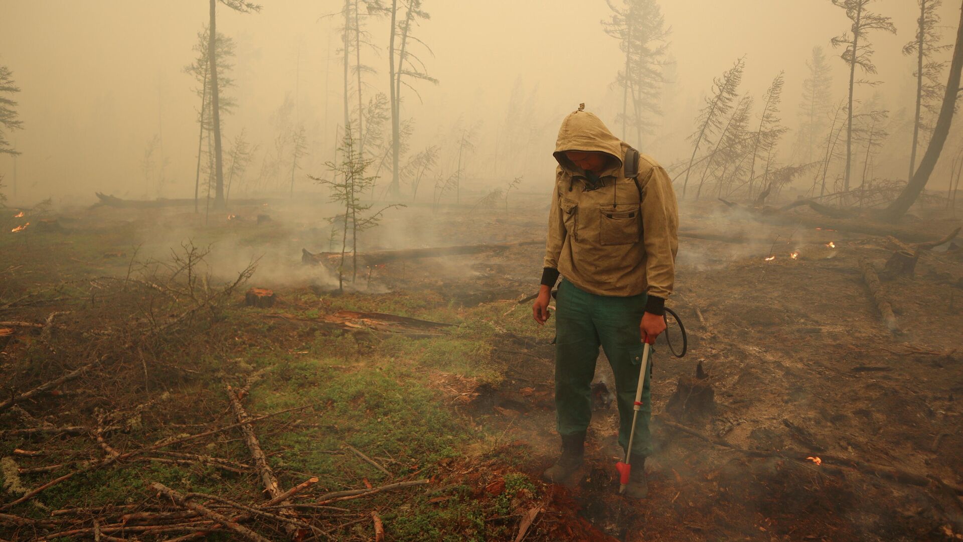 Un especialista del servicio local de protección forestal extingue un incendio forestal cerca del pueblo de Magaras en la región de Yakutia, Rusia, el 17 de julio de 2021 - Sputnik Mundo, 1920, 19.08.2021