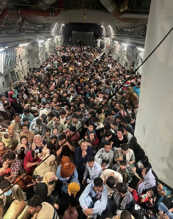 La gente evacuada agolpada en el interior de un avión de transporte C-17 Globemaster III de la Fuerza Aérea de Estados Unidos. El vuelo militar estadounidense logró evacuar a 640 afganos a Catar desde Kabul. La foto fue tomada el 15 de agosto de 2021. - Sputnik Mundo
