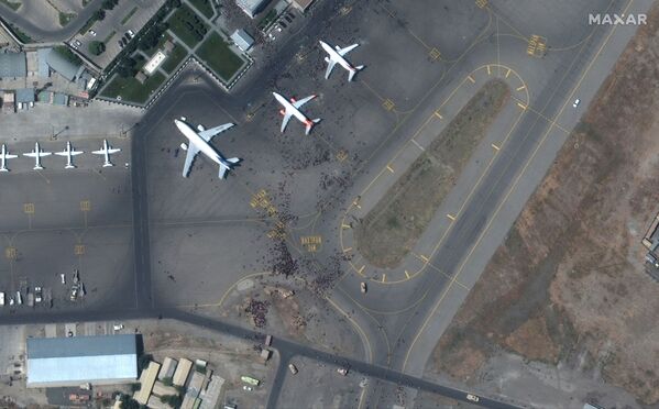 La pista del aeropuerto de Kabul llena de personas el 16 de agosto de 2021. Los militares estadounidenses tuvieron que abrir fuego de advertencia para dispersar a la muchedumbre de la pista de aterrizaje. Ya son más de 10 las víctimas mortales del caos que se desató en el aeropuerto. - Sputnik Mundo