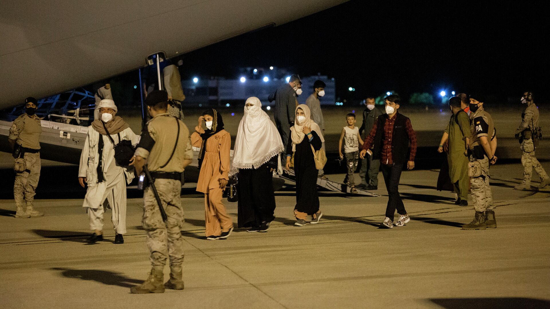 Varias personas repatriadas llegan a la pista tras bajarse del avión A400M en el que ha sido evacuados de Kabul, a 19 de agosto de 2021, en Torrejón de Ardoz, Madrid - Sputnik Mundo, 1920, 23.08.2021