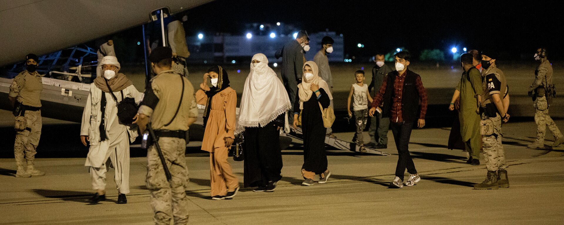 Varias personas repatriadas llegan a la pista tras bajarse del avión A400M en el que ha sido evacuados de Kabul, a 19 de agosto de 2021, en Torrejón de Ardoz, Madrid - Sputnik Mundo, 1920, 19.08.2021
