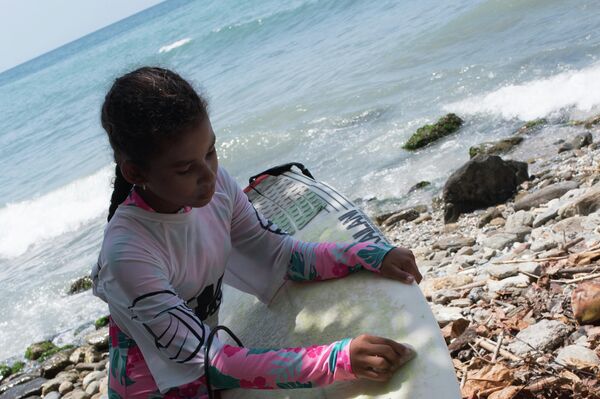 Una niña con su tabla de surf - Sputnik Mundo