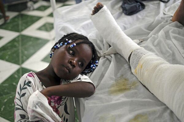 Una niña descansa al lado de su madre herida en el terremoto de Haití. - Sputnik Mundo