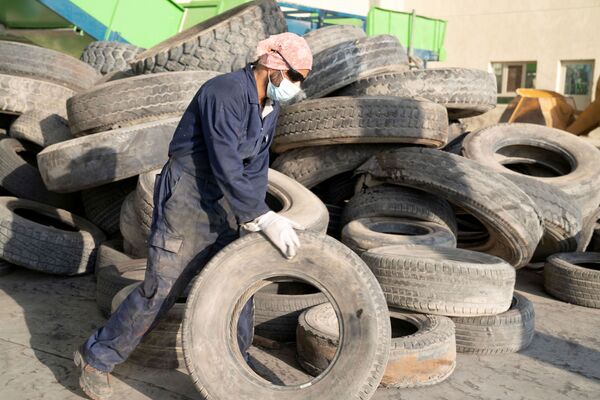 El contratista sirio Ibrahim Kamal selecciona los neumáticos que serán reciclados en la planta en Salmi, Kuwait. - Sputnik Mundo