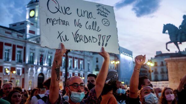 Un manifestante sostiene una pancarta durante una concentración contra las agresiones homófobas (Madrid) - Sputnik Mundo