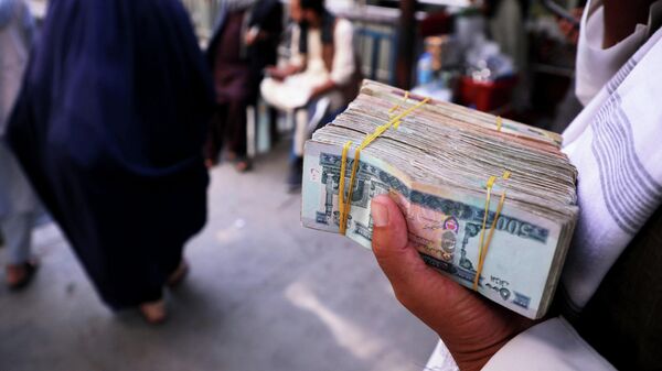 Un hombre con billetes de afganis en Kabul - Sputnik Mundo