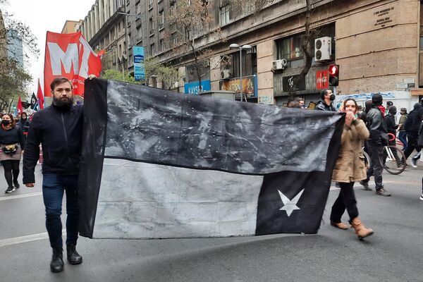 Una bandera chilena de luto y al revés durante la marcha para conmemorar a las víctimas de la dictadura chilena - Sputnik Mundo