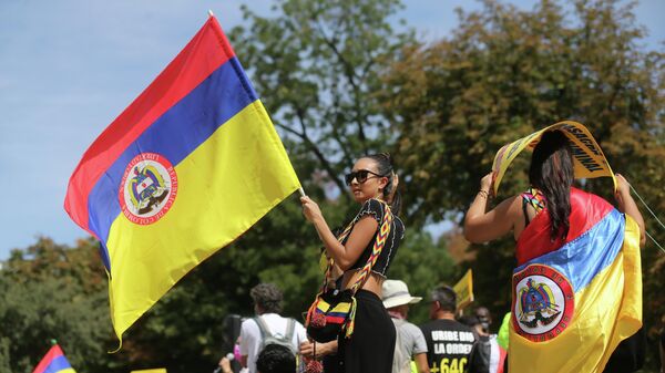 Una chica sostiene bandera de Colombia durante una manifestación contra la llegada del presidente del país a Madrid - Sputnik Mundo