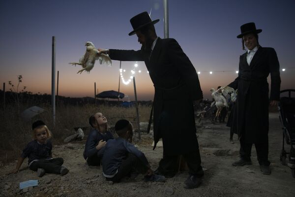 Un judío ultraortodoxo realiza el ritual Kapparot en la víspera de la fiesta judía más importante, el Yom Kipur, en Beit Shemesh (Israel). - Sputnik Mundo