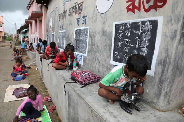 Unos niños en una clase al aire libre en una aldea de Bengala Occidental (la India) después de que las escuelas en el país fueran puestas en cuarentena debido a la epidemia del COVID-19. - Sputnik Mundo