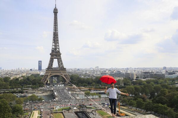 El equilibrista francés Nathan Paulin cruza el río Sena caminando por una cuerda de 670 metros de longitud tendida a 70 metros entre la Torre Eiffel y el Teatro Nacional de Chaillot en París, Francia. - Sputnik Mundo