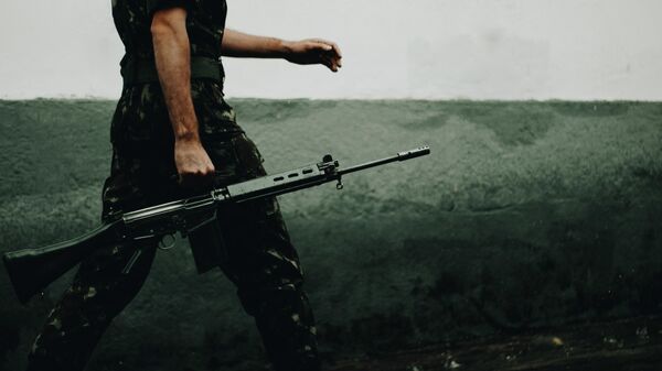 Un soldado sosteniendo un rifle - Sputnik Mundo