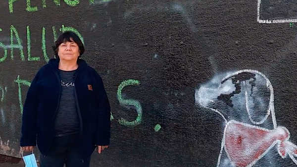 Alicia Lira, junto a un grafiti de la revuelta - Sputnik Mundo