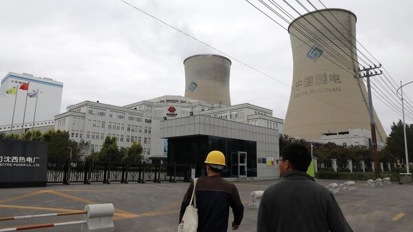 Unas personas caminan cerca a una central eléctrica de carbón en Shenyang, China - Sputnik Mundo
