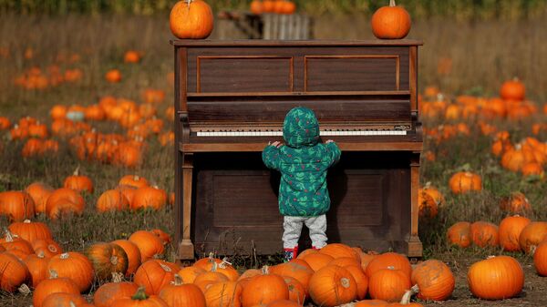 Ребенок играет на пианино на тыквенном поле фермы Pop Up Farm в Великобритании в преддверии Хэллоуина - Sputnik Mundo