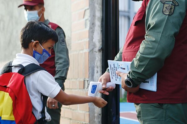 Funcionarios de la Guardia del Pueblo toman la temperatura a un niño durante el reinicio de clases presenciales en Venezuela - Sputnik Mundo