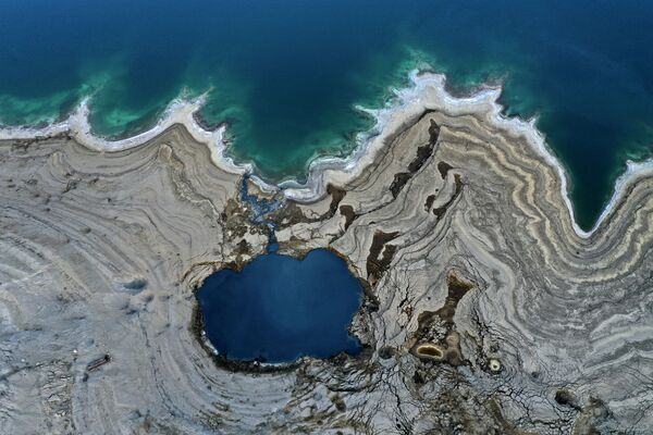 El mar Muerto ha perdido un tercio de su superficie desde la década de 1960. Cada año, sus aguas retroceden alrededor de un metro, dejando atrás un paisaje lunar repleto de agujeros. - Sputnik Mundo