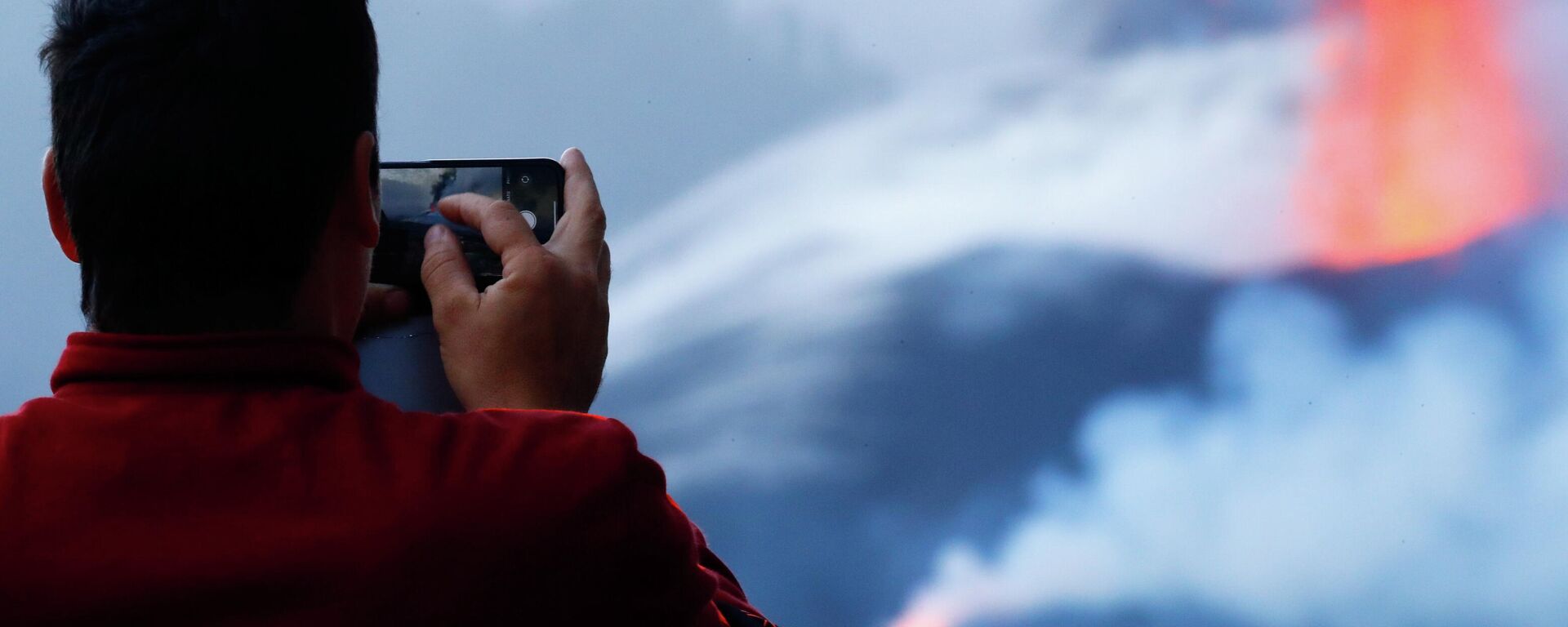 Un turista hace foto del volcán Cumbre Vieja con su móvil al amanecer, en la isla canaria de La Palma, España, el 24 de octubre de 2021 - Sputnik Mundo, 1920, 29.10.2021