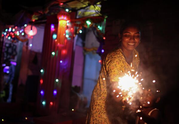 Durante estos días, la gente estrena ropa nueva, comparte dulces y hacen estallar petardos y fuegos artificiales.En la foto: la celebración del Diwali en Bombay (la India) - Sputnik Mundo
