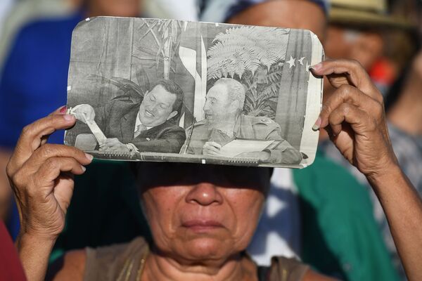 Una mujer acude a la ceremonia de despedida del fallecido Fidel Castro con un foto suya en manos, el 25 de noviembre de 2016. - Sputnik Mundo