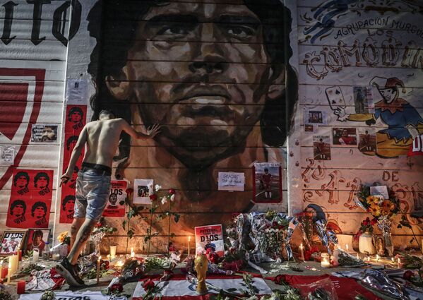 Un altar improvisado en homenaje a Maradona montado el día de su muerte en 2020 por los aficionados del equipo de fútbol Argentinos Juniors, en el cual actuó la leyenda del fútbol argentino. - Sputnik Mundo